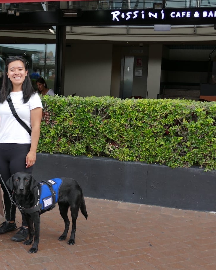 Diona and Murphy standing relaxed outside a city cafe